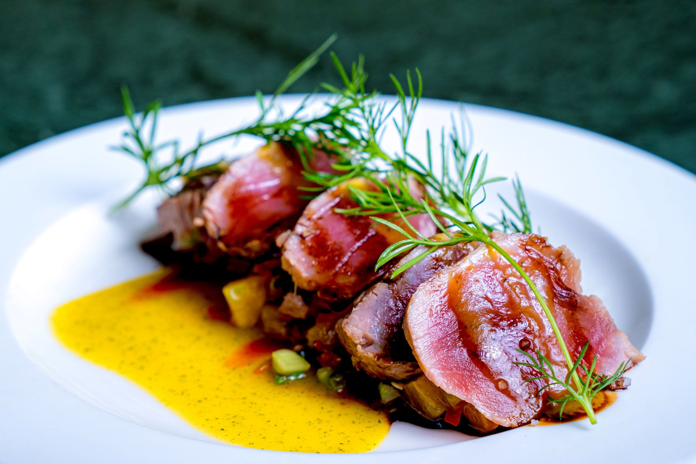 Seared tuna with dill on a white plate